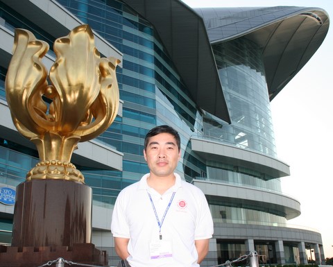 2006年12月8日，关公网站长关志杰在香港国际会展中心“盛开的紫荆花”前留影 